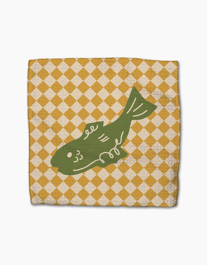 El Mar Dos by Geometry features a green fish illustration centered on a square napkin with a yellow and white checkered pattern, crafted from super-absorbent Geoweave fabric.