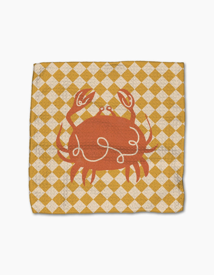 The Geometry El Mar Dos napkin features a centered red crab illustration on Geoweave fabric with a yellow and white diamond checkered background.
