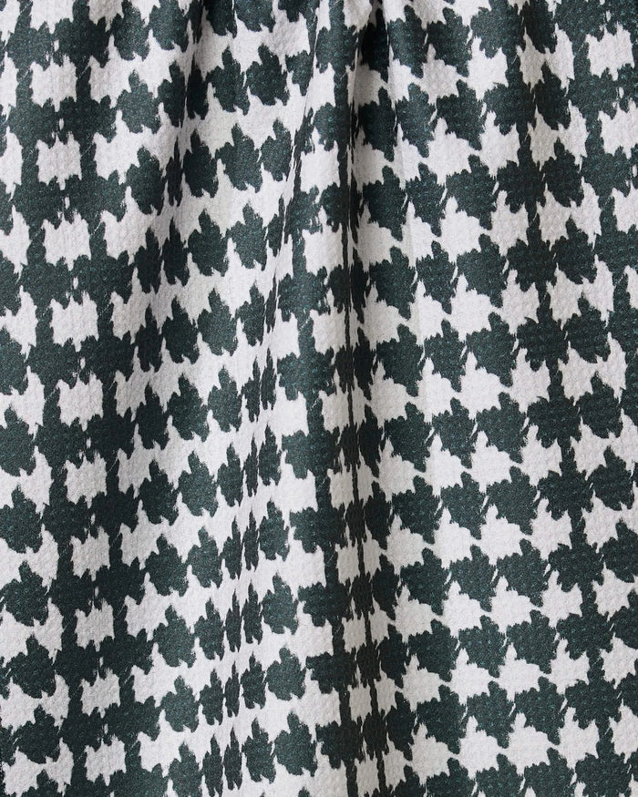Close-up of Geometrys Electric Houndstooth Black tea towel, featuring a black and white houndstooth pattern made from recycled materials, with gathered folds adding depth and texture.
