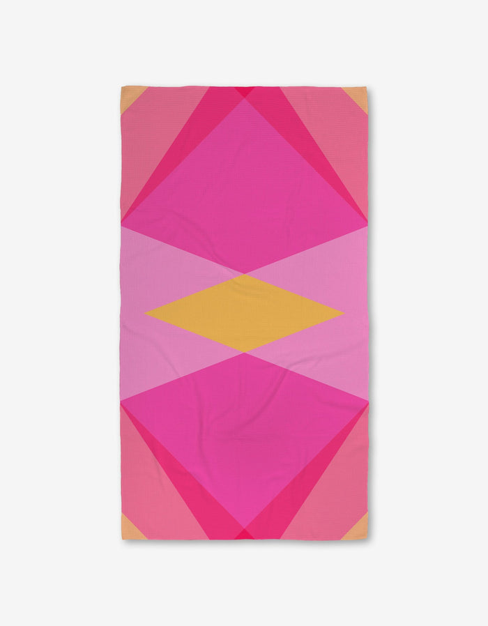 The GEOMETRY Electric Pink Luxe Bath Towel features a bold geometric pattern with overlapping pink, magenta, and yellow shapes on white, crafted from ultra-absorbent Geoweave fabric.