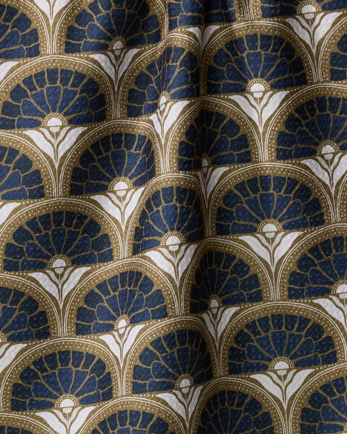 Close-up of the Eliza recycled kitchen towel by Amy MacCready, showcasing an Art Deco-inspired fan pattern in dark blue, gold, and white. Soft wrinkles add texture, highlighting the elegant curves and dot accents.