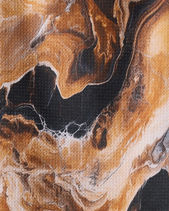 The Emperador towel by Geometry features abstract brown, black, and white marbled patterns inspired by natural stone—an ultra-absorbent design that adds visual depth and interest to any space.