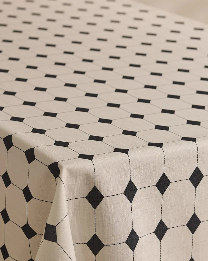 The Espresso Mosaic tablecloth by Geometry is lightweight, stain-resistant, and beige, featuring a stylish grid of black squares and lines that form octagonal shapes for a modern table look.