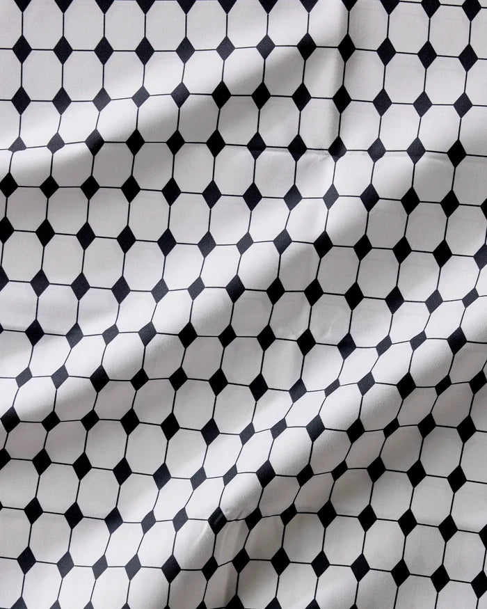 The Geometry Espresso Mosaic features a black and white hexagon and small square pattern with visible folds—an absorbent, stylish, and practical dinner napkins set.