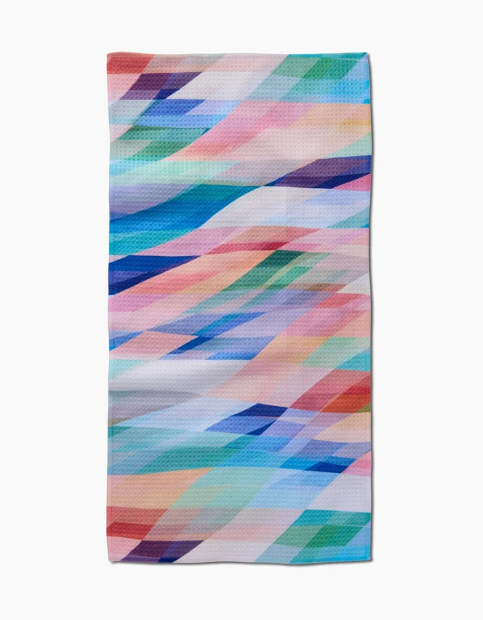 The Rachel Parker Eventide rectangular Bar Towel displays a vibrant abstract geometric pattern of overlapping blue, pink, purple, green, and orange shapes on white Geoweave fabric.
