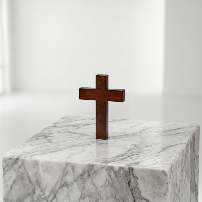 Wooden cross on a marble pedestal against a white background