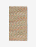 Fall Blossom by Kayla Ann is a rectangular fabric made from recycled materials with a beige background and a small, repeating floral pattern in red, green, and orange. Slightly uneven edges add unique charm to this decorative piece.