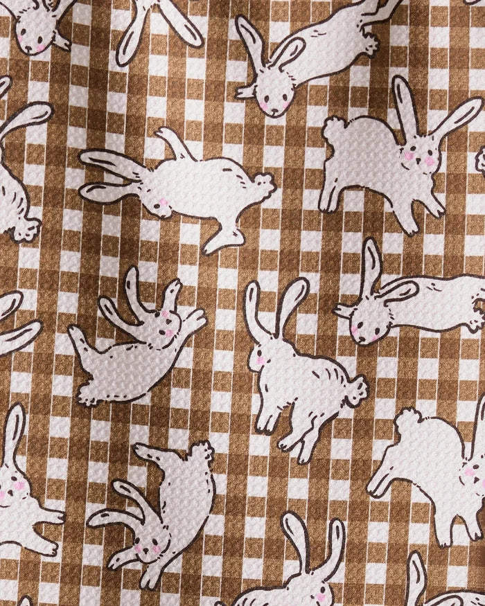 The Geometry Fall Bunny Hops towel features ultra-absorbent fabric with white cartoon rabbits, pink noses, and black outlines scattered on a brown and white checkered background—adding playful charm to any kitchen.