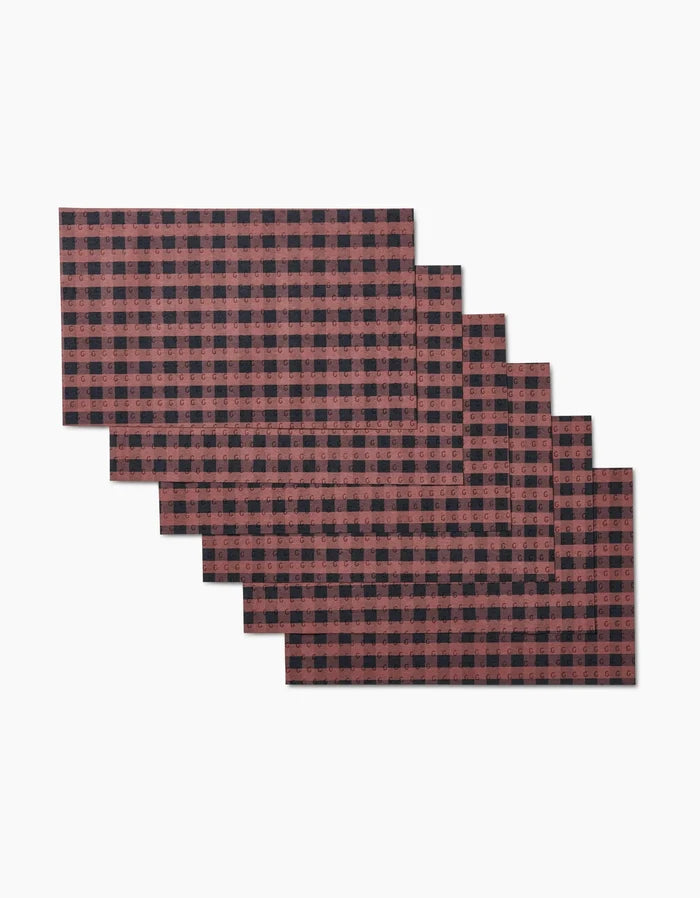 Six reusable rectangular GEOMETRY Fall Gingham placemats, featuring a red and black buffalo plaid design, are fanned out on a white background. Eco-friendly and ideal as Not Paper Towels for your table.