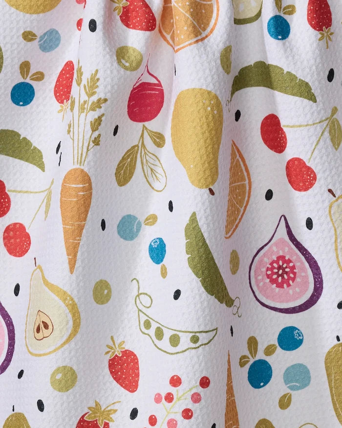 The Sara Mari "Farmers Market" tea towel is white and textured, made from recycled materials, and decorated with colorful illustrations of carrots, figs, peas, pears, oranges, strawberries, cherries, and leafy greens.