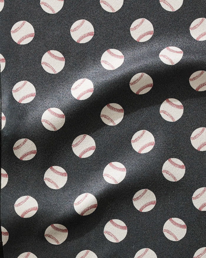 A close-up of the Geometry Fastball fitness towel shows ultra-absorbent fabric with a repeating white baseball pattern on dark background. Waves in the towel highlight its fast-drying properties and soft texture.