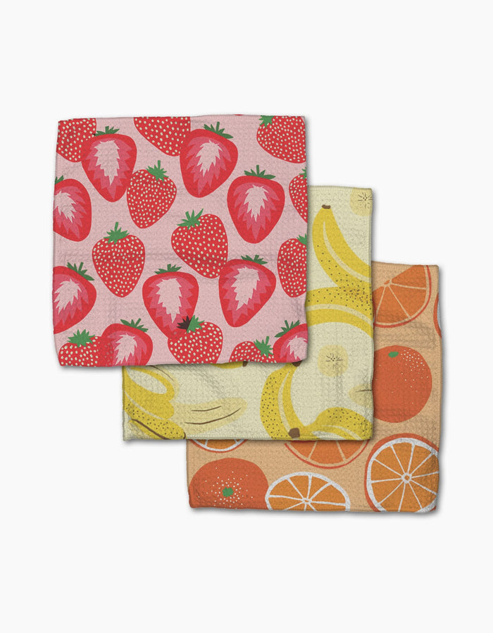 Geometry’s “Favorite Fruit” set features three patterned dishcloths made from recycled materials—each with red strawberries, yellow bananas, or orange slices on a white background.