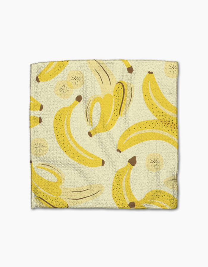 The Geometry Favorite Fruit napkin is made from Geoweave fabric and features a yellow banana print with whole, peeled bananas, and sliced rounds on a light background.