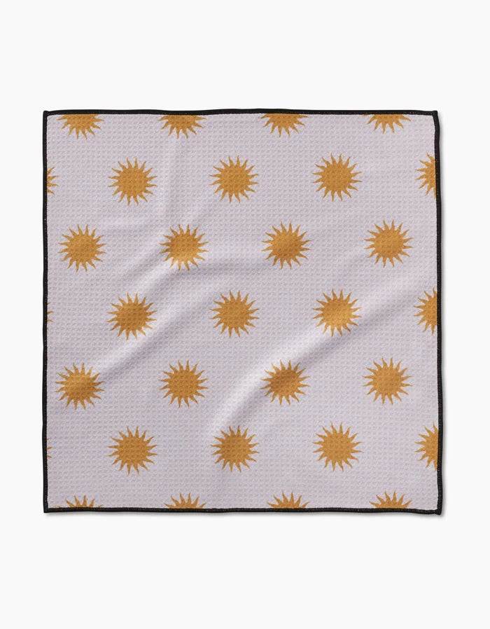 The Geometry Feeling Sunny cloth is made from ultra-absorbent Geoweave fabric. It features golden yellow sunbursts on a white background with black-outlined edges for a modern look.