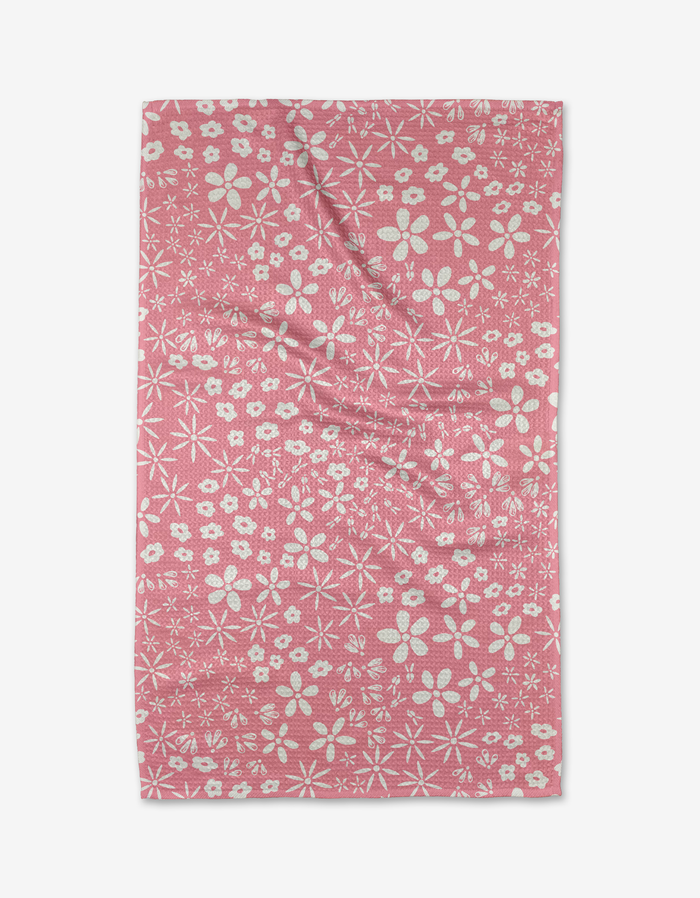 The Fields of Flowers towel by Hufton Studio features a pink background adorned with white flowers and star-like shapes, crafted to be ultra-absorbent.