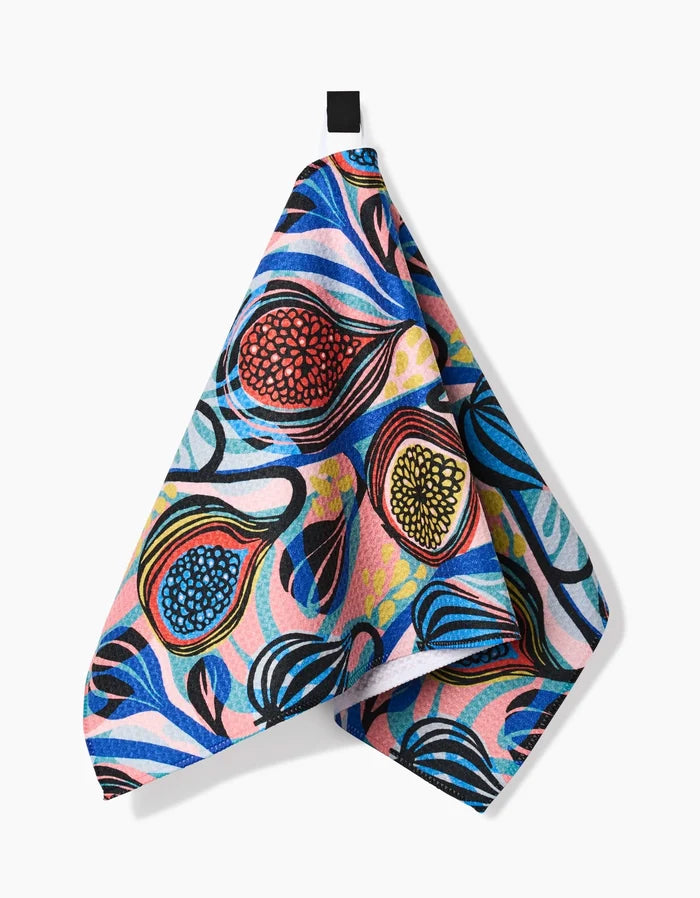 The Fig Garden bar towel by Masha Volnova features a vibrant abstract pattern with swirling blue, pink, and yellow shapes plus bold fruit-inspired accents. Crafted from Geoweave fabric, it hangs from a black loop against a white background.