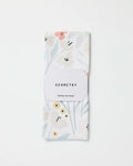 A folded white ultra-absorbent kitchen towel with a subtle floral pattern in soft pastels, labeled "Amy MacCready Fiona Cream," made from recycled materials and set against a plain white background.