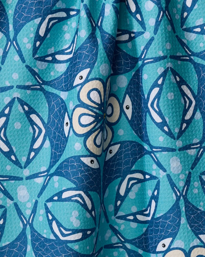Close-up of Marta Harvey's Fish Mandala tea towel, showcasing a vibrant aquatic-themed design with blue and turquoise stylized fish, geometric shapes, and white spots on quick-drying recycled fabric.