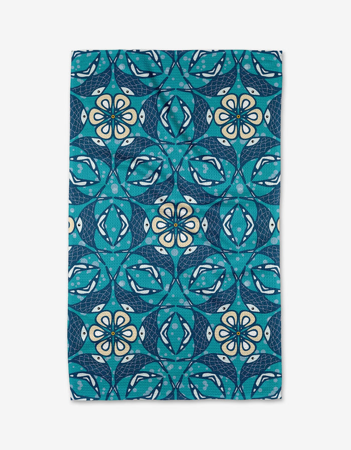 The Fish Mandala kitchen tea towel by Marta Harvey features a rectangular blue and teal design with repeating geometric and floral patterns in white, navy, and turquoise. Made from recycled materials for an eco-friendly touch.