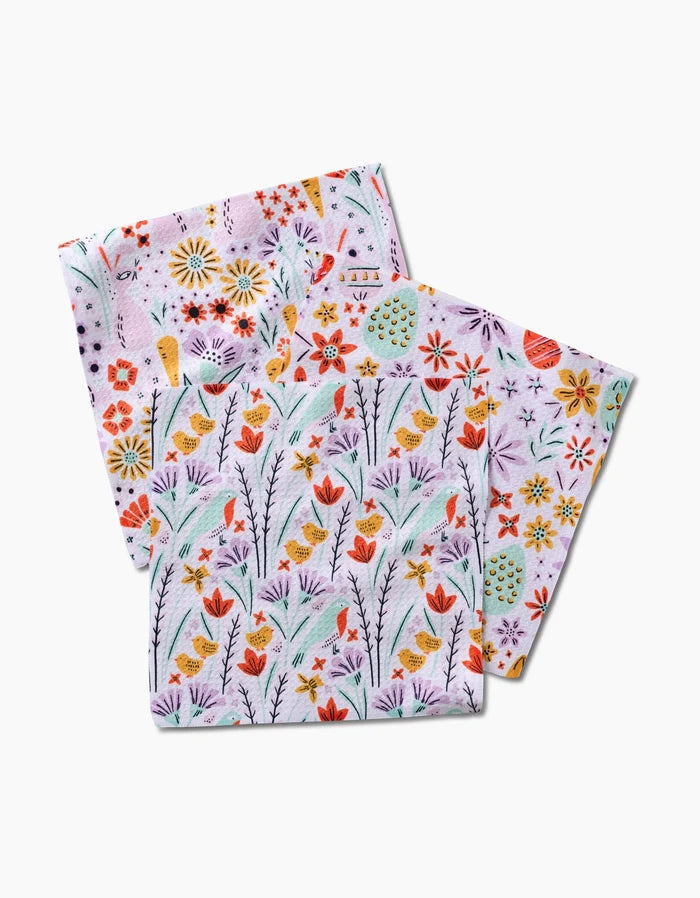 The Floppsie Lilith and Thaddeus dishcloth set by Amy MacCready features two folded cloths with yellow birds, red flowers, and colorful blooms on a light background, crafted from recycled materials.