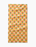 The Floral Bunny Parade kitchen towel by Ceyda Alasar features a yellow recycled fabric with red and pink tulips and white bunnies in a repeating pattern, shown slightly wrinkled on a white background.