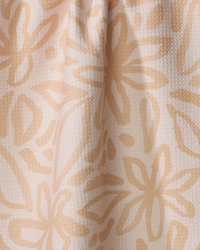 Close-up of the Jen B. Peters "Floral" dish towel: a textured, absorbent fabric with a soft beige background and light tan floral pattern, gently draped to create subtle folds and shadows.