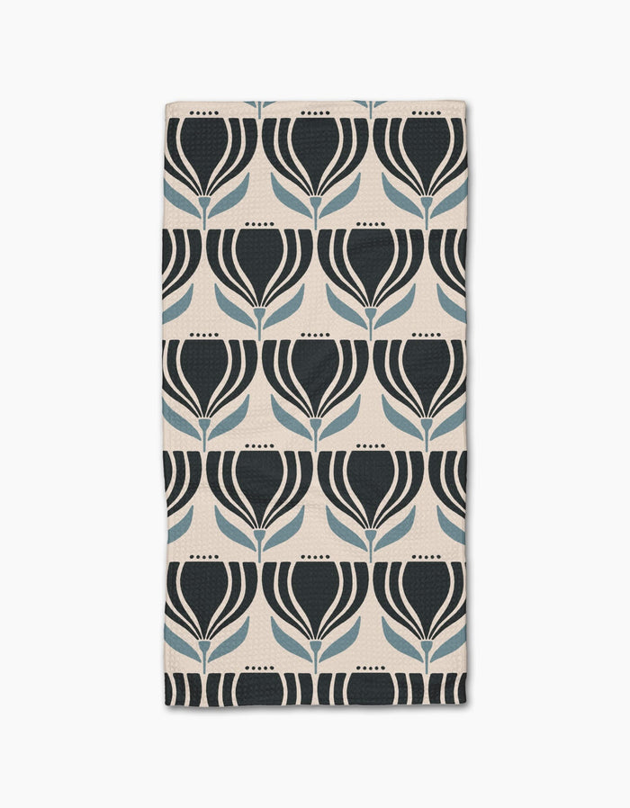 The Florian bar towel by Amy MacCready features a geometric tulip pattern in black and blue on a light beige Geoweave fabric, arranged in neat rows and columns.