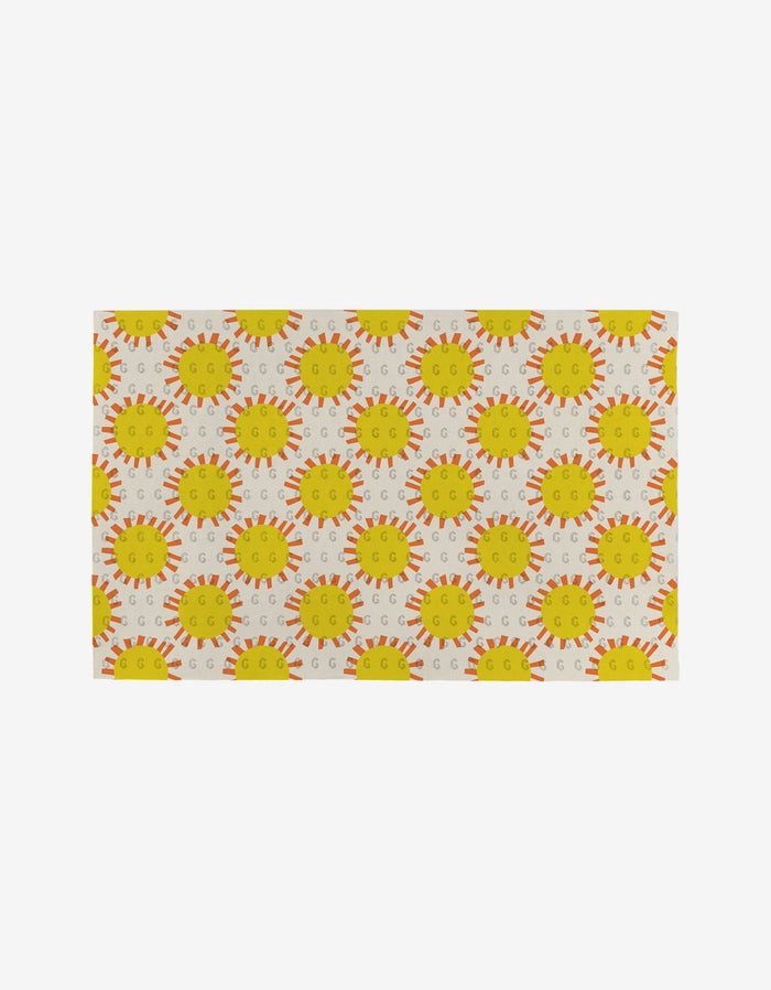 The Lizzie Clark Flower Parade rug features a cheerful, eco-friendly design with repeating yellow suns and orange rays on a light backdrop. Made from post-consumer recycled materials, it adds playful charm while caring for the environment.