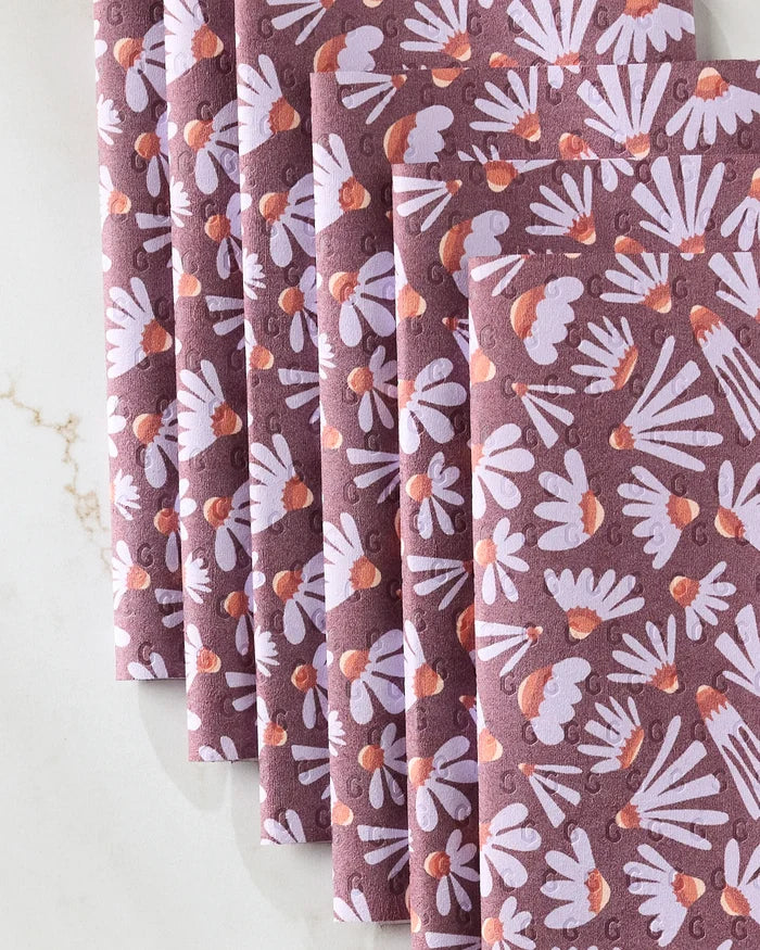 Five Elisabeth Wing "Flower Pop" reusable paper towels, featuring a mauve, orange, and white floral pattern, are fanned out on a marble surface—a stylish and eco-friendly kitchen towel alternative.