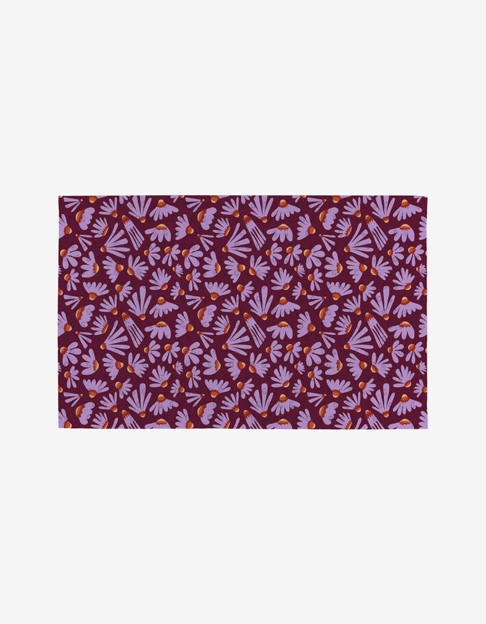 The Flower Pop rug by Elisabeth Wing has a maroon base with pink and purple leaf motifs and small orange accents, crafted from post-consumer recycled materials for an eco-friendly touch.