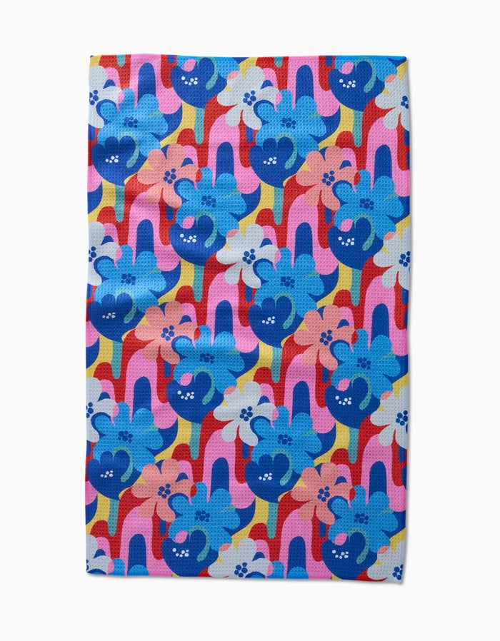 Introducing Flower Powers by Masha Volnova: a vibrant tea towel with stylized blue dogs—some with flower crowns—on a wavy pink, red, and yellow background. Made from post-consumer recycled materials.