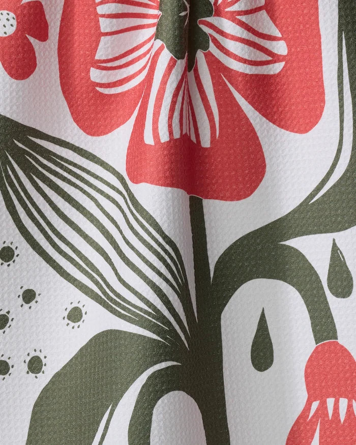 Close-up of the Flower Stamp kitchen tea towel by Ash Cascade, featuring a bold red, green, and white abstract floral print with textured weave. Made from recycled materials.