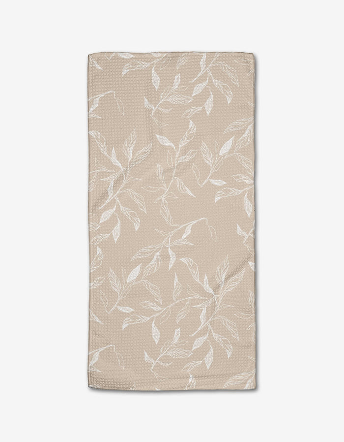 Aubrey Fairchilds Flowing Floral tea towel is beige, rectangular, and crafted from Geoweave fabric with a subtle texture and a white leaf and branch design.