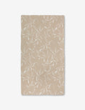 Aubrey Fairchilds Flowing Floral Luxe Bath Towel, beige and rectangular with a white leafy branch pattern and Geoweave technology, is laid flat on a white background.