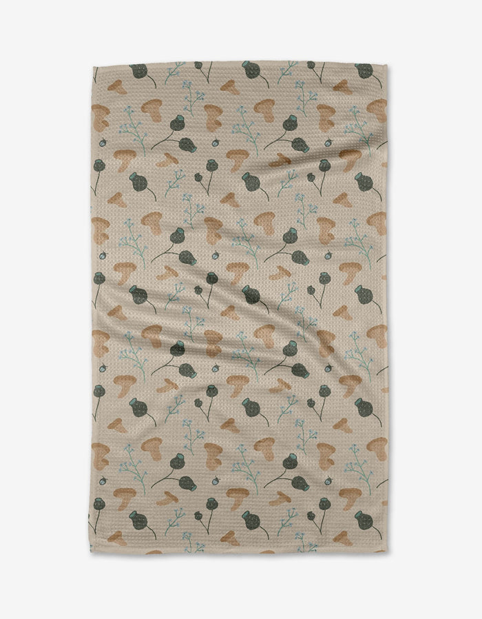 The Forage tea towel by Amberleigh Adoff features a beige textured surface adorned with abstract brown, green, and blue botanical shapes, inspired by leaves and stems, arranged evenly across the fabric.