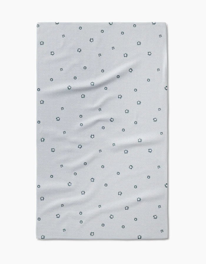 The Forest Daisy Tea Towel by Coit Creative features a light gray design with dark blue outlined circles and stars on soft, slightly wrinkled Geoweave™ fabric for enhanced durability and absorbency.