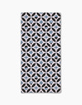 The Forest Findings rectangular bar towel by Anette Heiberg showcases black and light blue geometric shapes on white Geoweave fabric, blending circles, diamonds, and abstract floral motifs in a stylish pattern.