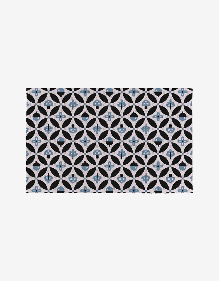 Forest Findings by Anette Heiberg features a repeating geometric tile pattern with blue and black circles, crosses, and petal shapes on a light background—a symmetrical, eco-friendly decorative motif.