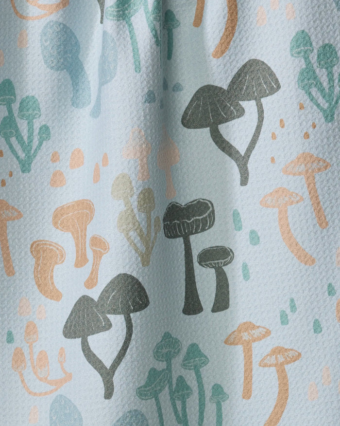 The Forest Friends kitchen towel by Amberleigh Adoff features a playful mushroom pattern in blue, orange, and gray on textured recycled fabric, bringing a whimsical, nature-inspired accent to your kitchen.