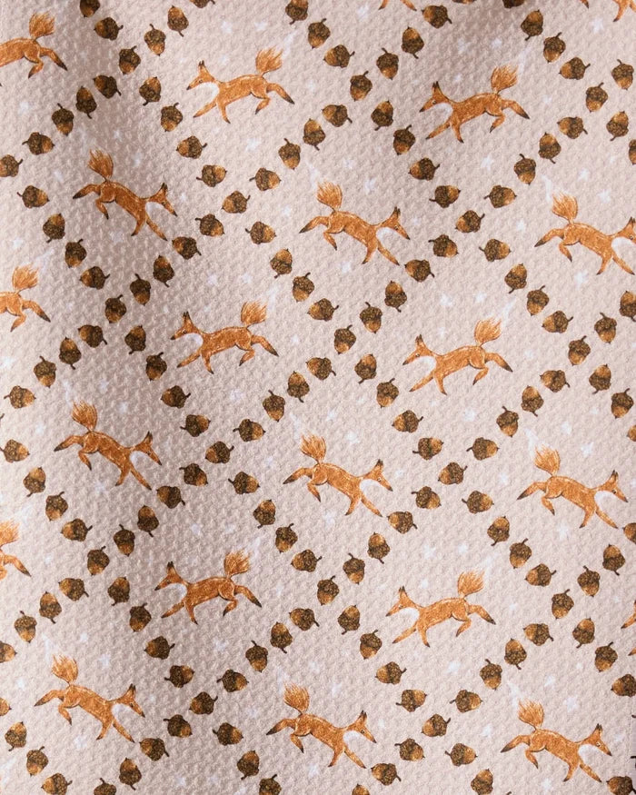 The Geometry Foxes and Twinkles bar towel showcases orange running foxes and brown twinkles in a diagonal grid on light beige, crafted from recycled materials.