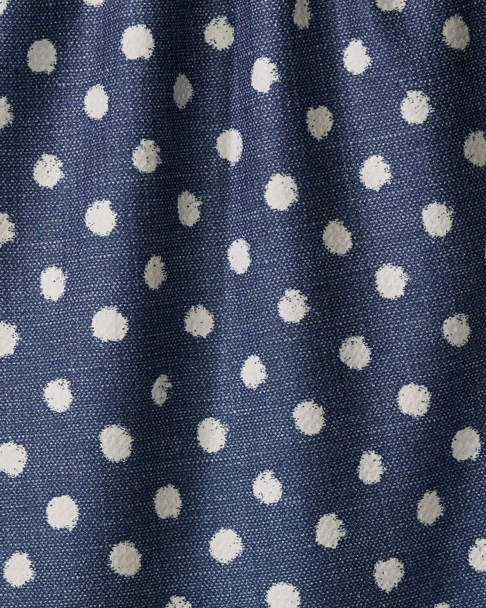 Close-up of Geometry's Freckle Jean tea towel, featuring blue recycled fabric with a white polka dot pattern. The textured material is softly gathered, highlighting gentle folds and shadows.