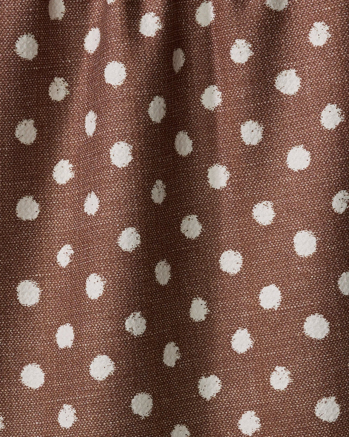 A close-up of the Geometry Freckle Off White tea towel, featuring a brown fabric with a white polka dot pattern and subtle wrinkles.
