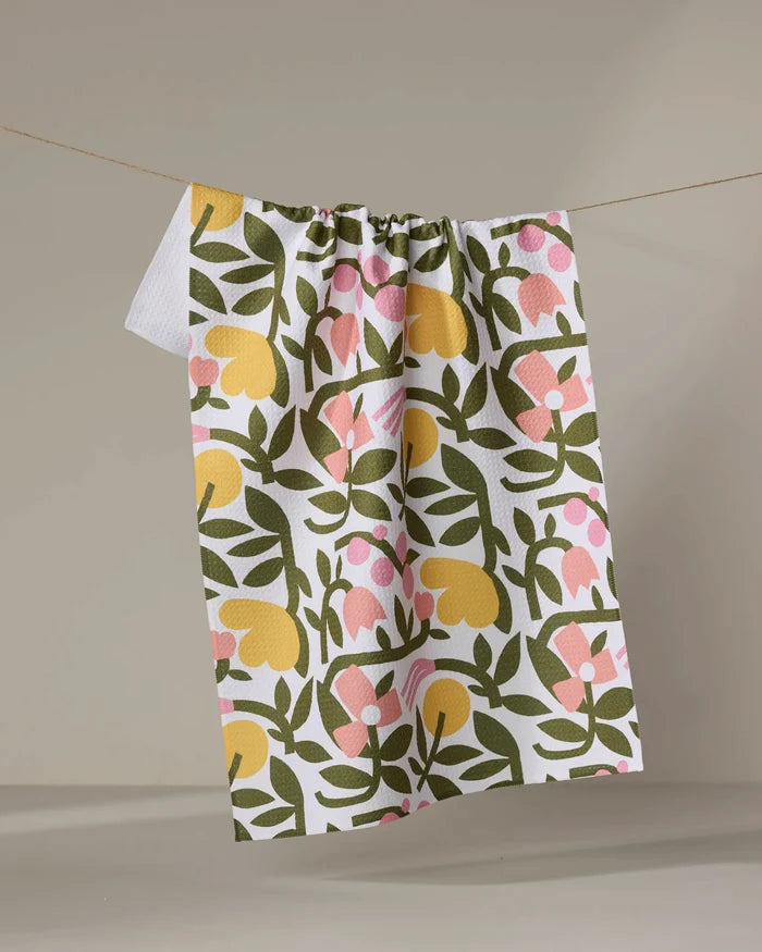The Fresh Vines tea towel by Lisa Nelson features a colorful green, yellow, and pink floral pattern on white Geoweave fabric. It hangs on a beige string against a neutral background, perfect for everyday use.