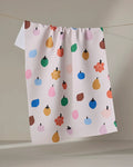 The "Fruit Basket" tea towel by Jennifer Bouron is made from recycled materials and features a lively pattern of colorful apples, pears, berries, and dots on a neutral background, bringing cheerful charm to your kitchen.