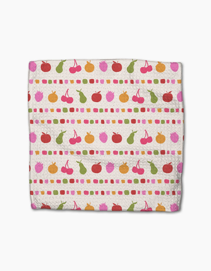 The Fruits At The Party napkin by Geometry is made from Geoweave fabric and features colorful cherries, oranges, and pears in rows with pink, green, and orange dotted lines on a cream background.