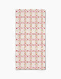The Fruits Plaid by Geometry is a rectangular white bar towel with a grid of red and pink dots plus green accents forming squares, evenly repeated on Geoweave fabric.