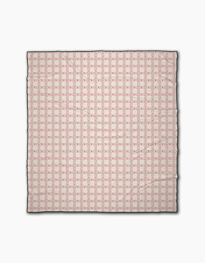 The Geometry Fruits Plaid is a square cloth beach blanket featuring a geometric pattern of small red squares and lines on a cream background with a thin black border. Its quick-drying design is evenly repeated across the entire surface.