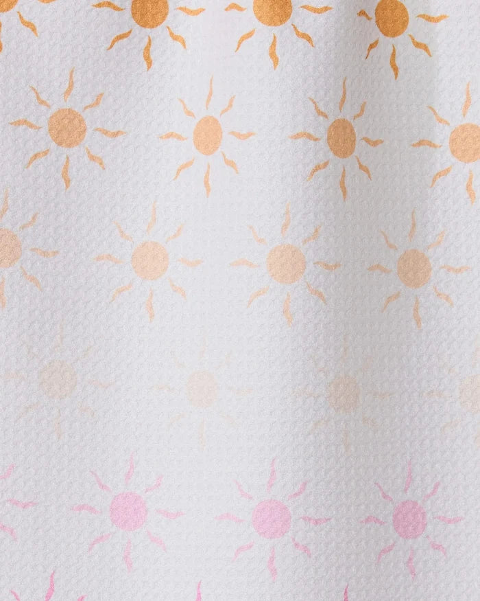 Fun in the Sun by GEOMETRY features rows of small sun patterns, orange fading to pink on textured white—ideal for inspiring an ultra-absorbent towel made from recycled materials.