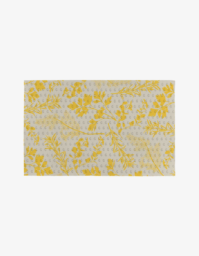 Garden of Gold by GEOMETRY features a rectangular beige cloth adorned with yellow botanical motifs and gray dots—an eco-friendly Not Paper Towels option, pictured on a plain white background.