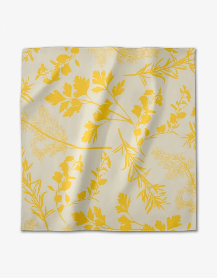 The GEOMETRY Garden of Gold napkin features a cream Geosuede™ fabric with yellow botanical silhouettes of leaves and branches. Made from recycled materials, its lightly wrinkled look makes it perfect for elegant dining.